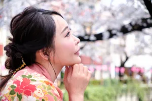 Side profile of actress Minami Airi in a floral pink kimono under cherry blossom trees in Tokyo.