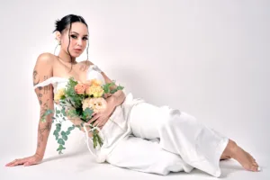Woman in white holding a floral bouquet during an editorial studio session, by JG in Tokyo.