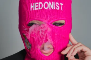 Close-up brand portrait of a model in a pink balaclava for Tokyo streetwear label Hedonist, by JG.